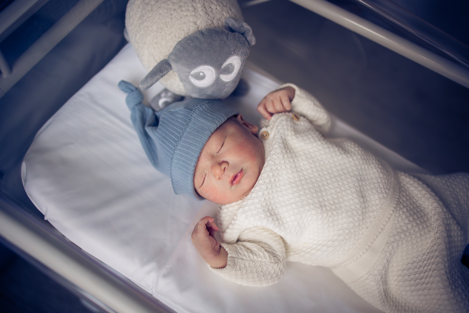 Blue Hat Baby Sleeps In Bassinet